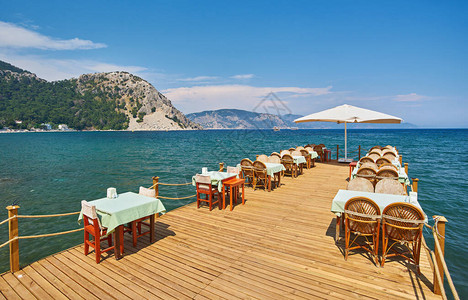 传统的希腊街咖啡厅有鲜花空桌椅和街道图片