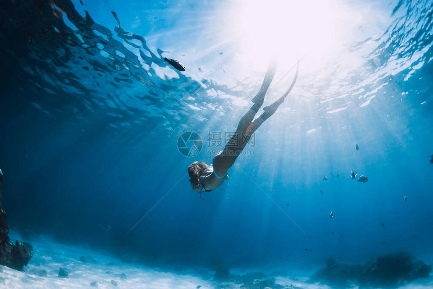 女自由潜水员其鳍在蓝大洋下水珊瑚附近图片