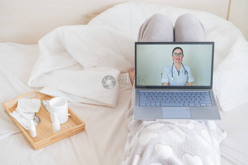 一名妇女在隔离期间使用笔记本电脑与医生交流女孩仰面躺着看医学视频博客医生图片