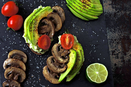 加蘑菇和樱桃西红柿的健康的鳄梨烤面包图片