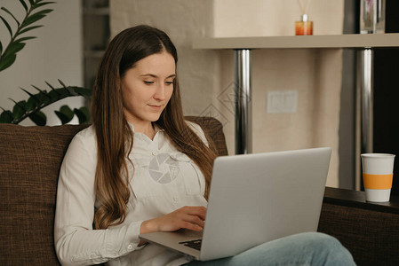 远程工作一名白人妇女在她的笔记本电脑上远程工作一位女商人坐在沙图片