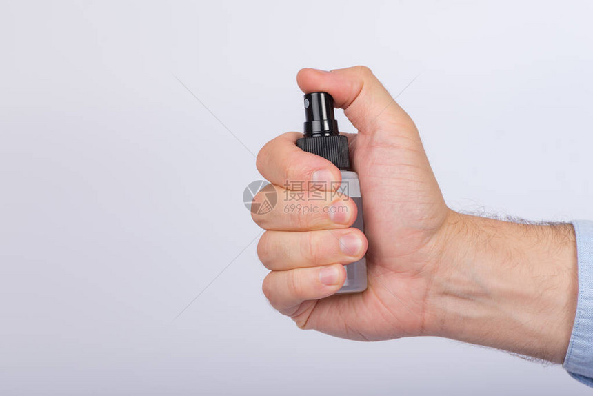 白底的男手上的小喷雾瓶抗微生图片