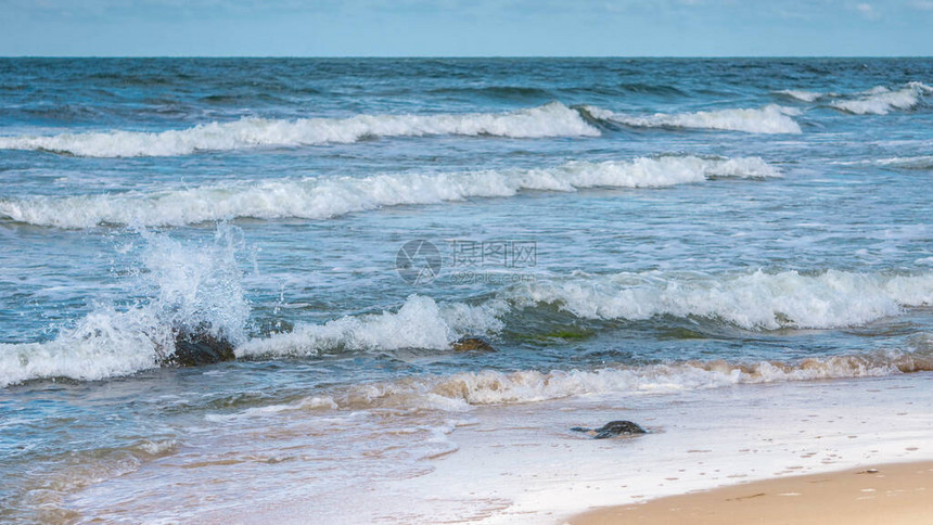 海浪在海岸附近的海中覆盖石头在风暴中被海浪冲刷的岩石沙滩附近海水图片