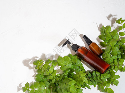化妆品瓶容器和白色背景上的绿色植物天然有机产品美容博主沙龙疗法品牌模型背景图片