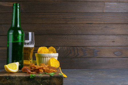 秘鲁鱿鱼和啤酒柠檬和薯片在黑木板上鱼肉加啤酒图片
