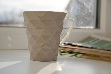 窗台上有咖啡和报纸的杯子图片