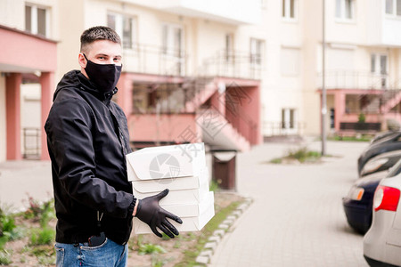 穿黑色制服戴黑色保护面具和手套的送粮员用白箱将图片