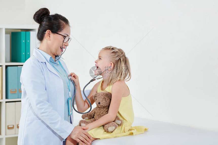 医生让小女孩在体检前玩听诊器让她感觉舒服图片