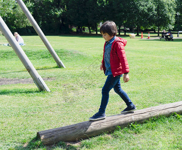 侧视孩子在公园的木制攀爬上行走图片
