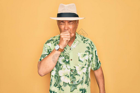 中年老灰发男子穿着暑假帽和沙滩度假时穿花岗衬衫图片