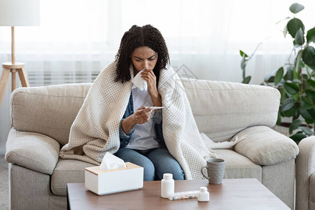FluSymptoms非洲女在家检查身体温度图片
