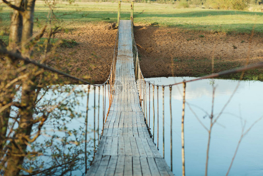 河上旧的悬浮木脚桥照片于夏日拍摄人们图片