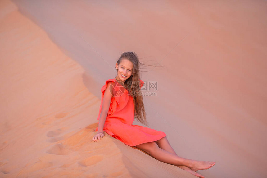 小女孩在阿拉伯联合酋长国沙漠的沙图片