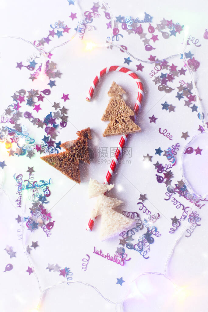 圣诞或新年节日背景请看由面包制成的带条纹的糖果闪光灯和木头树组成的贺图片