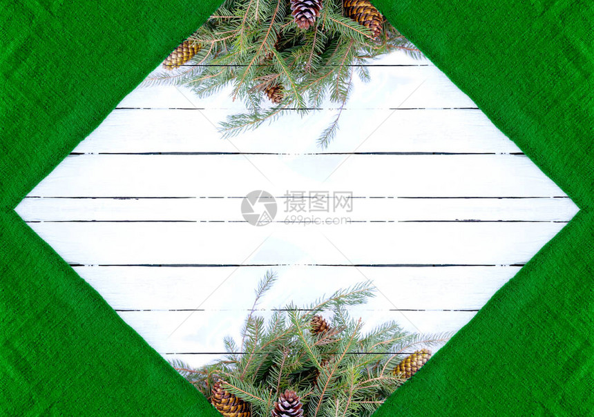 圣诞组成与冷杉树枝和锥在白色岁的木制背景绿色羊毛质地节日设计模板对称框架带有空白间的装饰边图片