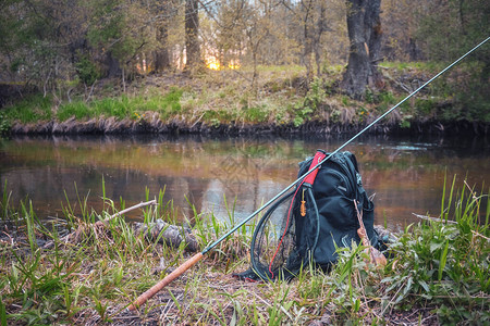 钓鱼棒背包和渔具在河岸的T图片