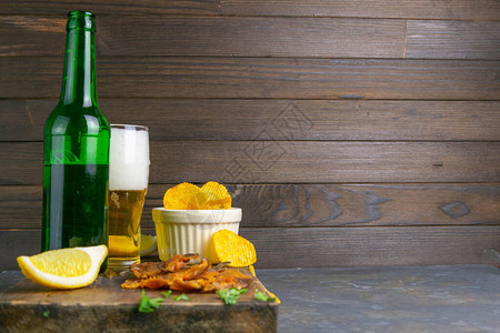 在黑木板上用啤酒柠檬和薯片干得满地都是鱼吃着啤酒图片