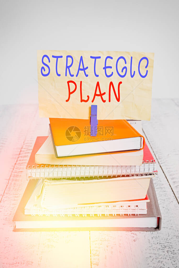 显示战略计划的文本符号商业照片文本定义策略和决策的过程堆放书籍笔记本别针衣夹彩色图片
