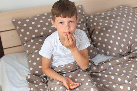 儿童为该疾病服药男孩坐在床上图片