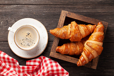咖啡和在木制桌上的羊角面包早餐图片