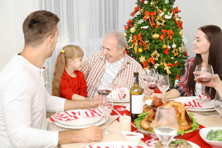 在客厅吃圣诞晚餐的幸福家庭图片