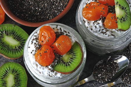 酸奶加奇异果猕猴桃和金橘白酸奶和罐子里的水果健身早餐健康背景图片