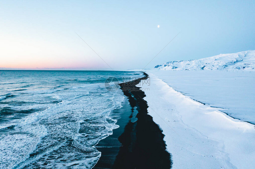 在冬季与雪中总部一起在冰岛的美丽黑滩被图片