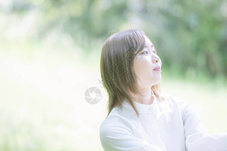 亚洲年轻女子在公园里散步神色轻松背景图片