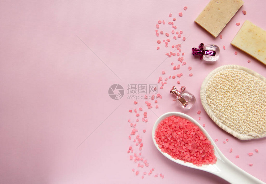 白色勺子里的天然浴盐浴海绵手工皂粉红色背景的香水瓶身体护理有机沐浴产品的概念温泉化妆品平图片