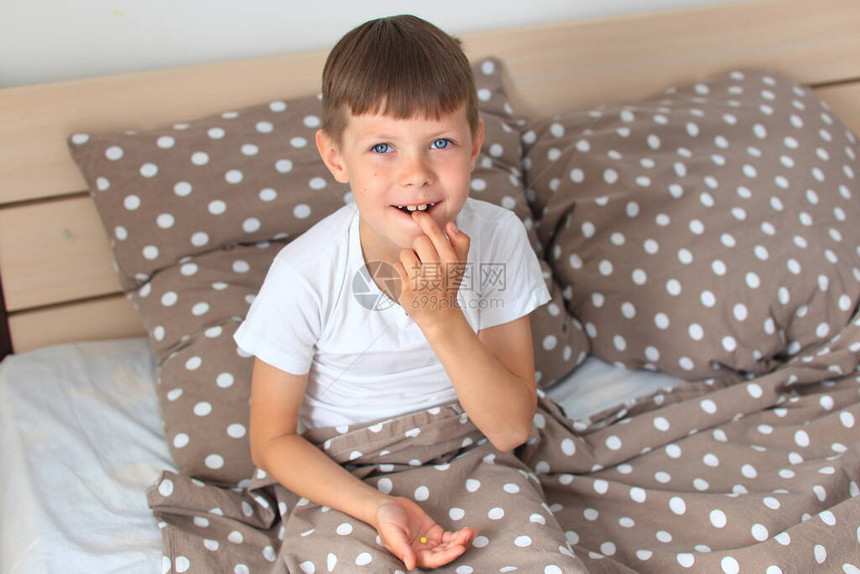 儿童为该疾病服药男孩坐在床上图片