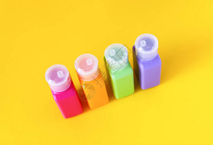 光黄色背景的护肤产品的彩色塑料瓶用于图片