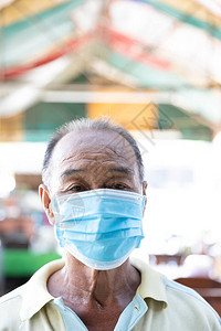 餐厅背景下亚洲老人戴面具的特写脸保护冠状图片