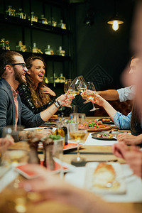 一群最好的朋友坐在餐厅里祝酒和庆祝一图片