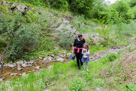 家庭享受大自然在溪边漫步远足人们图片