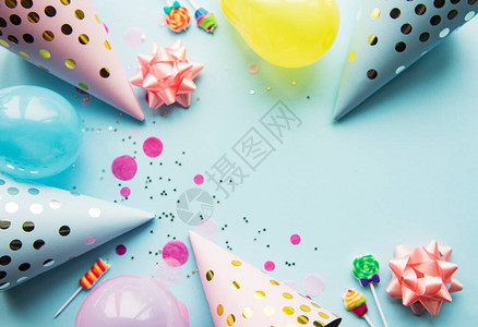 生日快乐或派对背景平躺在蓝色背景上的生日帽五彩纸屑和丝带顶视图片