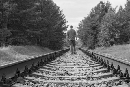 孤独的人走在铁轨上黑白色调图片