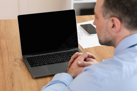 手持空白屏幕制作视频呼叫的笔记本电脑商人与办公室内的同事举行在线会议图片
