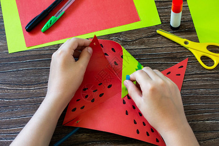 折纸指导步骤9纸风车有趣的玩具西瓜风车在木桌上旋转儿童艺术项目针线活图片