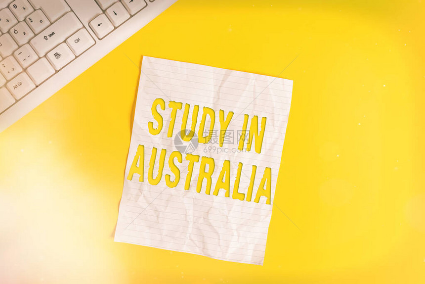 显示在澳大利亚学习的文字符号展示进入外国订单的商务照片完成您的学习在黄色背景上方的笔记本上复制空间图片