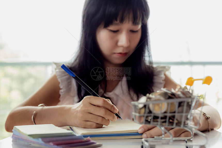 亚洲女手写在笔记本上的选择焦点图片
