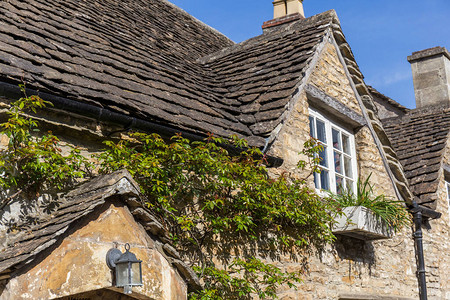 有一栋典型的英国石屋顶有黑瓷砖和攀爬植图片