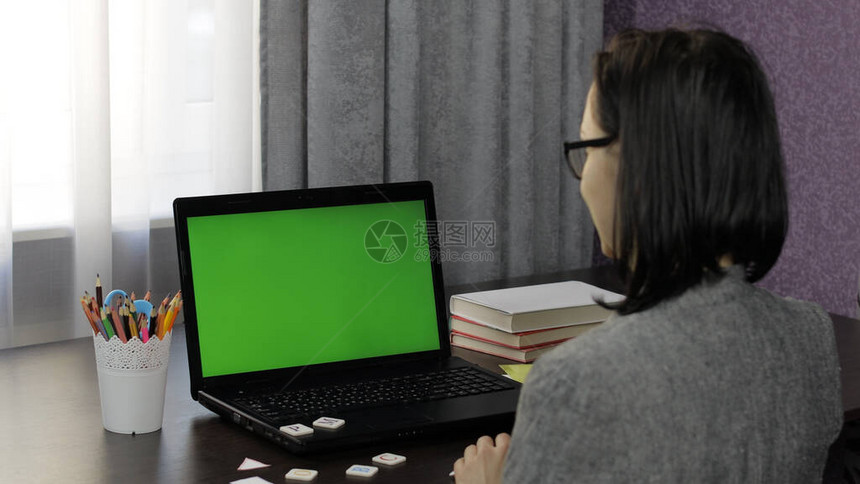 女教师在带绿屏色度键的笔记本电脑上进行在线视频通话远程教育聊天在家工作图片