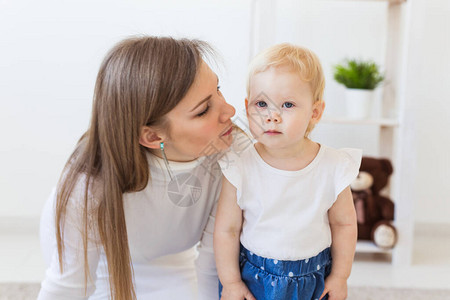 年幼的母亲在家和她的女婴玩耍母亲图片