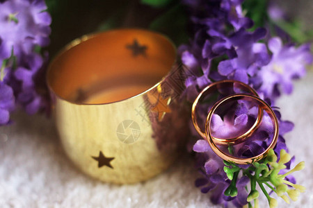 婚礼细节两个金婚戒指放在一个紫花瓣上图片