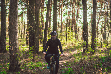 活跃的运动型女在森林小径上骑山地自行车图片