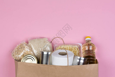 粉红色背景检疫隔离期间供应危机食品的纸袋图片