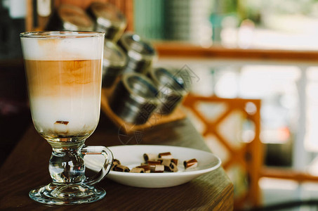 木桌上的玻璃杯里的热拿铁咖啡早上自制咖啡放松的时间概图片