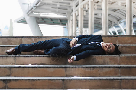 疲惫而失望的年轻亚洲商人躺着图片