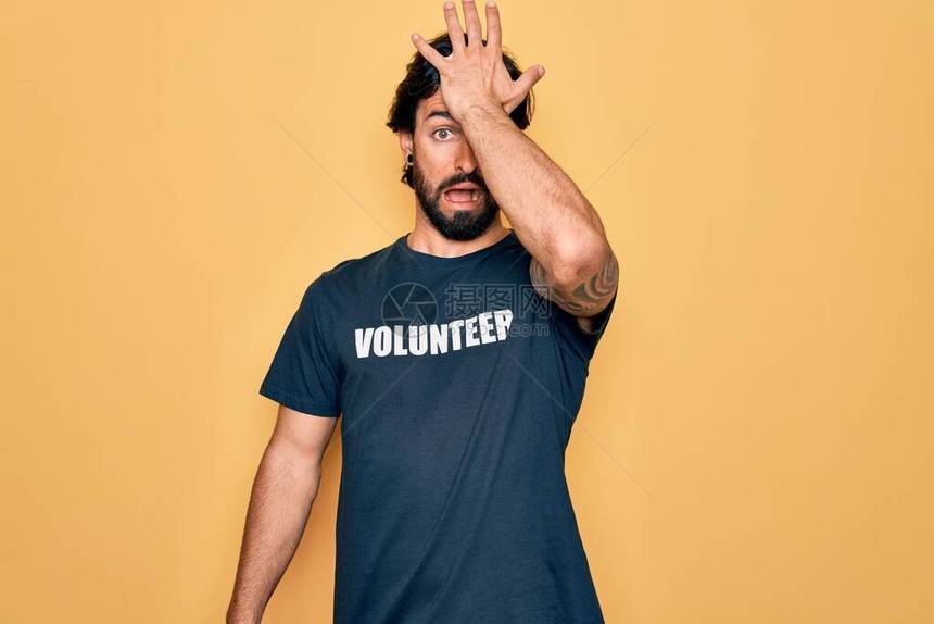年轻英俊的西班牙志愿者男子穿着志愿T恤作为社会关怀图片
