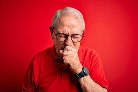 灰色头发的老年男子戴眼镜和穿红色背景感觉不舒服图片